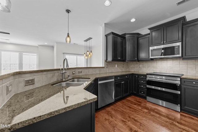 9164 Wooden Rd, Raleigh, NC 27617 - kitchen with appliances with stainless steel finishes, a sink, light stone countertops, dark wood-type flooring, and recessed lighting