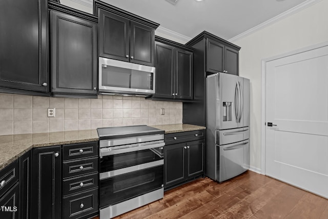 9164 Wooden Rd, Raleigh, NC 27617 - kitchen with stainless steel appliances, dark cabinets, ornamental molding, dark wood-style flooring, and light stone countertops