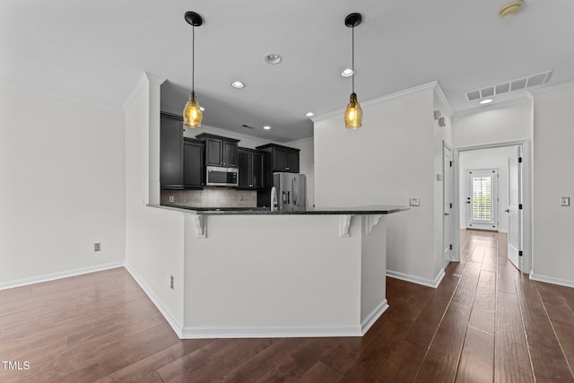 9164 Wooden Rd, Raleigh, NC 27617 - kitchen featuring appliances with stainless steel finishes, ornamental molding, dark cabinetry, a breakfast bar, and recessed lighting