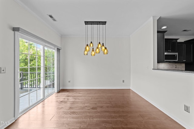 9164 Wooden Rd, Raleigh, NC 27617 - unfurnished dining area with ornamental molding, a chandelier, wood finished floors, and baseboards