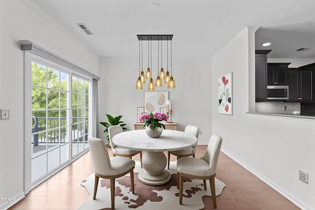 9164 Wooden Rd, Raleigh, NC 27617 - dining area with crown molding, a chandelier, light wood-type flooring, and baseboards