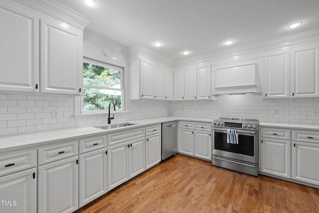 1706 Rangecrest Rd, Raleigh, NC 27612 - kitchen with stainless steel appliances, a sink, premium range hood, white cabinetry, and recessed lighting