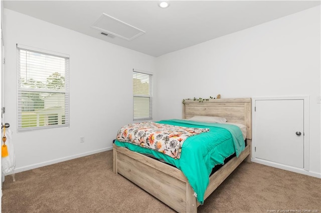 bedroom featuring attic access, carpet flooring, and baseboards