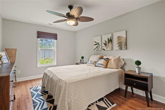 bedroom with wood finished floors, baseboards, and a ceiling fan