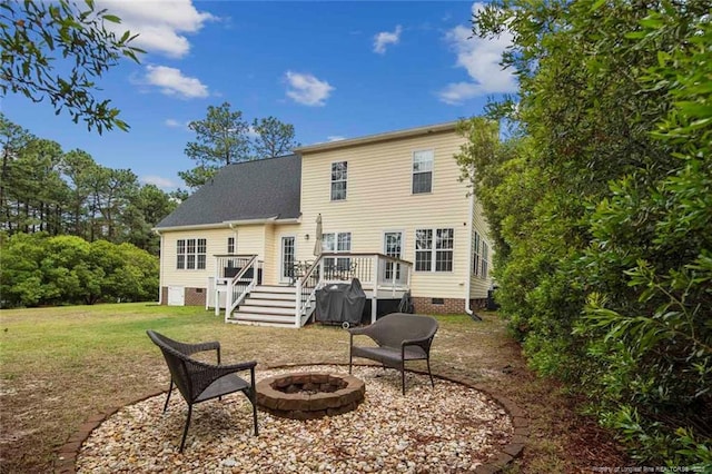 rear view of house with crawl space, an outdoor fire pit, stairway, a deck, and a lawn