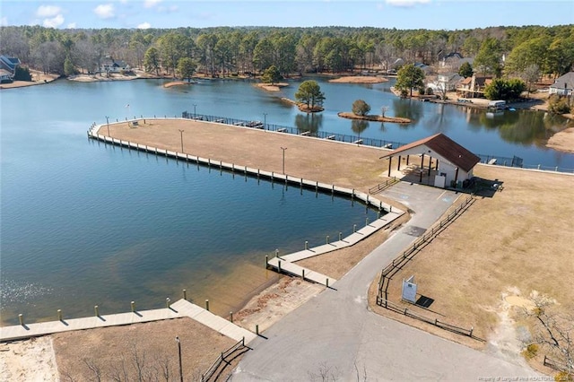 view of swimming pool with a water view and a wooded view