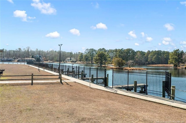 view of swimming pool featuring a water view and fence