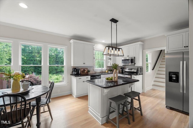 kitchen with appliances with stainless steel finishes, crown molding, white cabinets, plenty of natural light, and recessed lighting