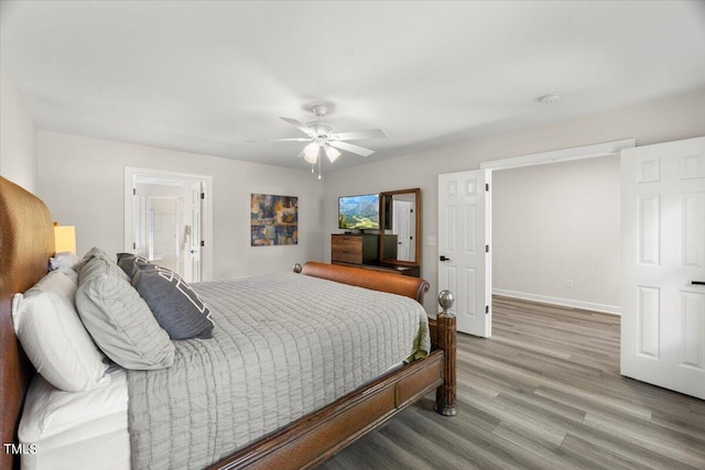 bedroom with light wood-type flooring, a ceiling fan, baseboards, and connected bathroom