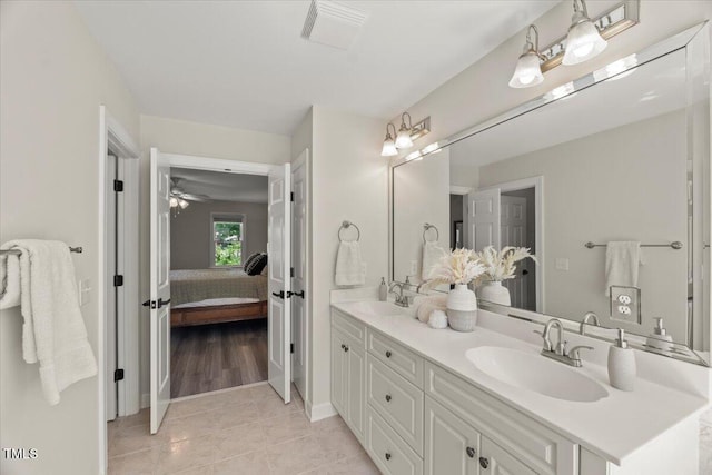 full bath featuring double vanity, tile patterned floors, baseboards, connected bathroom, and a ceiling fan