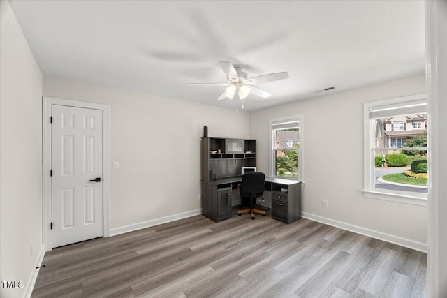 home office featuring wood finished floors, ceiling fan, and baseboards