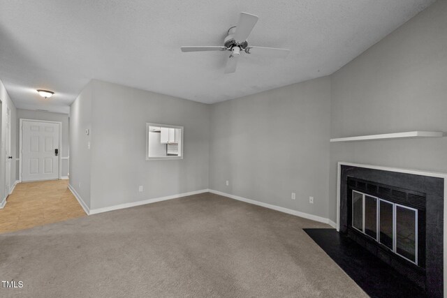4631 Timbermill Ct Unit 203, Raleigh, NC 27612 - unfurnished living room with a fireplace with flush hearth, carpet floors, baseboards, ceiling fan, and a textured ceiling