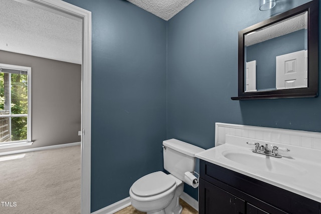 4631 Timbermill Ct Unit 203, Raleigh, NC 27612 - bathroom featuring a textured ceiling, toilet, vanity, and baseboards