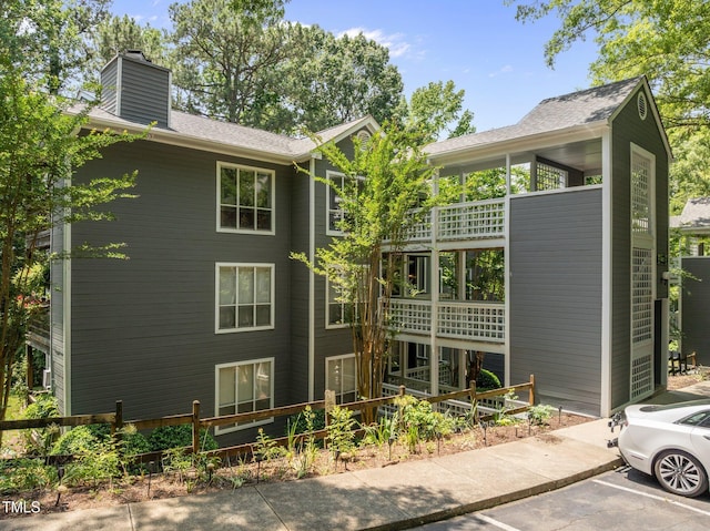 4631 Timbermill Ct Unit 203, Raleigh, NC 27612 - view of home's exterior featuring uncovered parking, a chimney, and a balcony