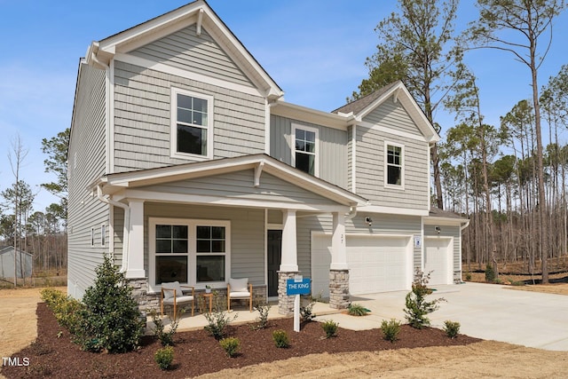27 Cribbs Ln, Middlesex, NC 27557 - view of front of home featuring covered porch, an attached garage, concrete driveway, and stone siding