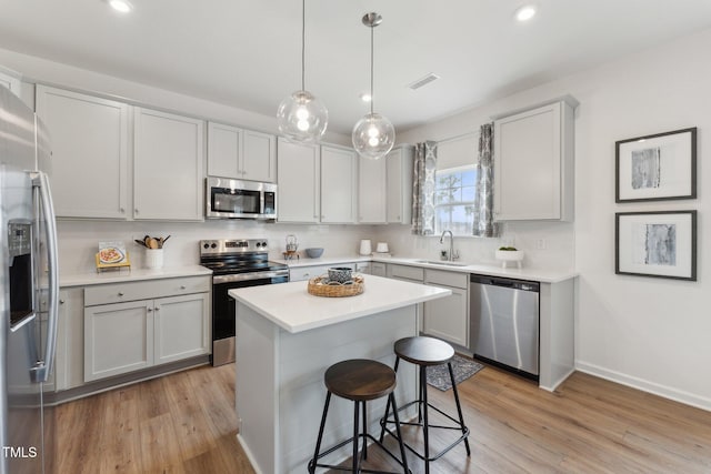 27 Cribbs Ln, Middlesex, NC 27557 - kitchen featuring appliances with stainless steel finishes, a sink, light wood-style flooring, a kitchen bar, and recessed lighting