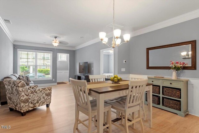 1213 Treetop Meadow Ln, Wake Forest, NC 27587 - dining area featuring light wood-type flooring, ornamental molding, a chandelier, and wainscoting