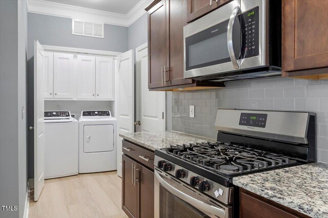 1213 Treetop Meadow Ln, Wake Forest, NC 27587 - kitchen featuring stainless steel appliances, washing machine and clothes dryer, ornamental molding, tasteful backsplash, and light stone countertops