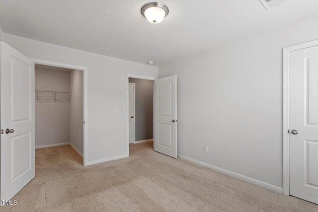 1213 Treetop Meadow Ln, Wake Forest, NC 27587 - unfurnished bedroom with carpet floors, a walk in closet, baseboards, and a closet