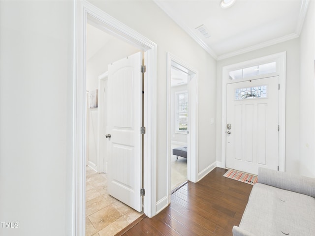 entryway with ornamental molding, baseboards, and wood finished floors