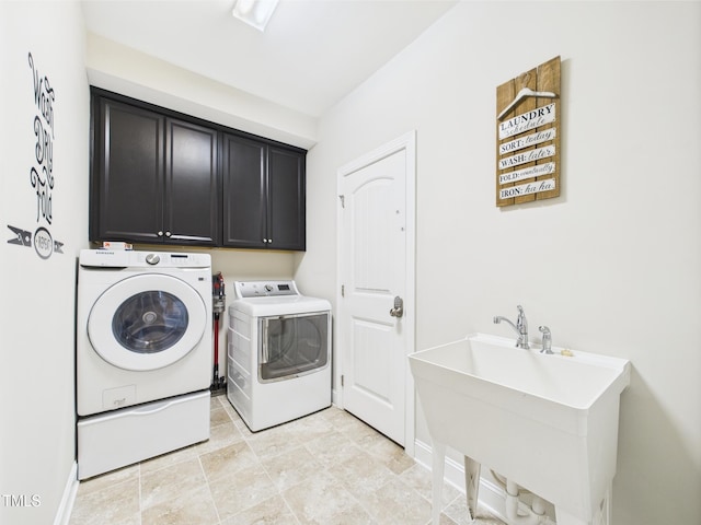 clothes washing area featuring cabinet space, washing machine and clothes dryer, and baseboards