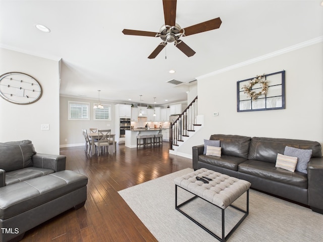 living room with ornamental molding, a ceiling fan, stairway, dark wood finished floors, and recessed lighting