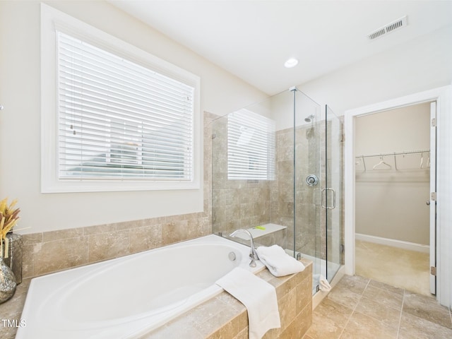 full bathroom featuring a shower stall, a walk in closet, and a bath