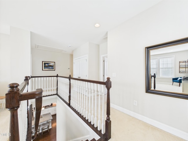 hallway with an upstairs landing, attic access, baseboards, recessed lighting, and carpet flooring