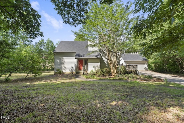 view of front of property featuring concrete driveway, an attached garage, a shingled roof, and a front yard