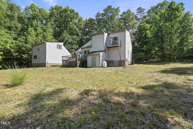 view of grassy yard with a storage unit, an outdoor structure, a wooden deck, central AC, and view of wooded area