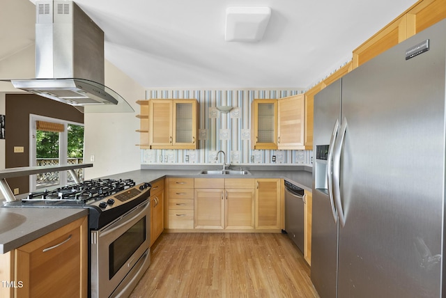 kitchen featuring appliances with stainless steel finishes, a sink, wall chimney exhaust hood, light brown cabinetry, and light wood-style floors