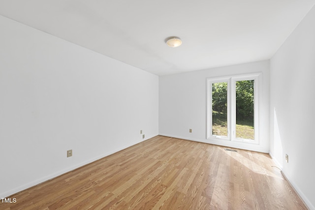 spare room with light wood finished floors and baseboards