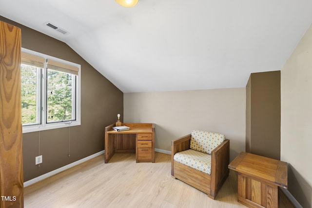 living area with light wood-type flooring, lofted ceiling, and baseboards