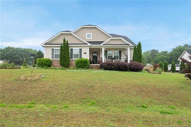 craftsman inspired home featuring covered porch and a front yard