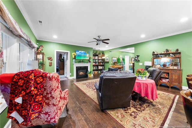 living room featuring ornamental molding, ceiling fan, a fireplace with flush hearth, recessed lighting, and dark wood-type flooring