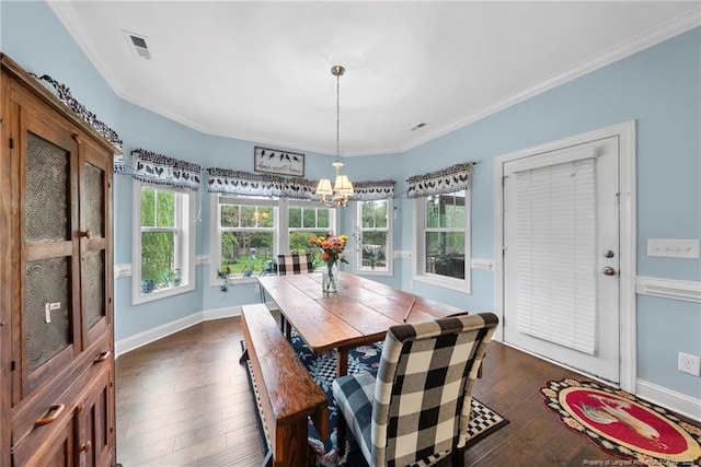 dining space featuring a chandelier, dark wood-style flooring, healthy amount of natural light, baseboards, and crown molding