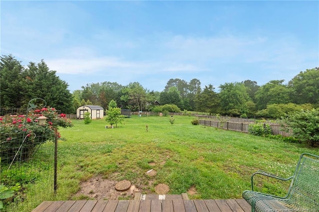 view of yard featuring a shed, an outdoor structure, and a deck