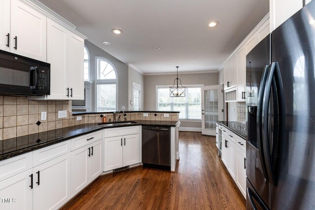 120 Gentle Rain Dr, Garner, NC 27529 - kitchen featuring black appliances, a sink, dark wood-style floors, ornamental molding, and a peninsula