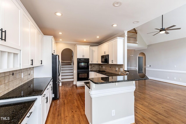 120 Gentle Rain Dr, Garner, NC 27529 - kitchen featuring black appliances, arched walkways, white cabinetry, a ceiling fan, and wood finished floors