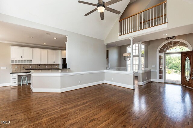 120 Gentle Rain Dr, Garner, NC 27529 - unfurnished living room featuring ceiling fan, high vaulted ceiling, dark wood-style flooring, baseboards, and recessed lighting