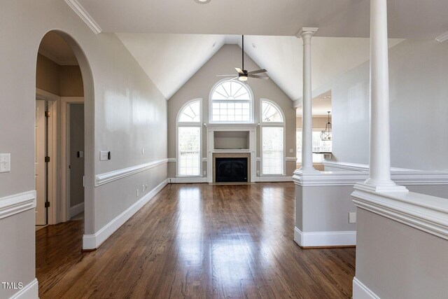 120 Gentle Rain Dr, Garner, NC 27529 - unfurnished living room featuring ceiling fan, wood finished floors, a fireplace with flush hearth, vaulted ceiling, and ornate columns