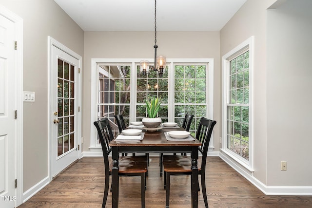 dining area with a chandelier, baseboards, and dark wood finished floors