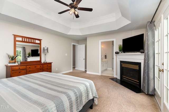 bedroom with a raised ceiling, carpet, a fireplace with flush hearth, baseboards, and ornamental molding