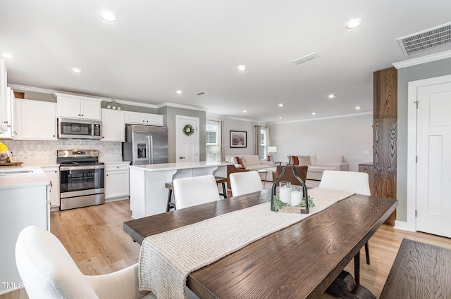 8615 Kenridge Ln, Fuquay Varina, NC 27526 - dining area featuring ornamental molding, light wood finished floors, and recessed lighting
