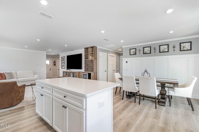 8615 Kenridge Ln, Fuquay Varina, NC 27526 - kitchen featuring crown molding, light wood-style flooring, open floor plan, a center island, and recessed lighting