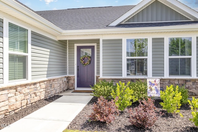 8615 Kenridge Ln, Fuquay Varina, NC 27526 - property entrance featuring stone siding, roof with shingles, board and batten siding, and covered porch