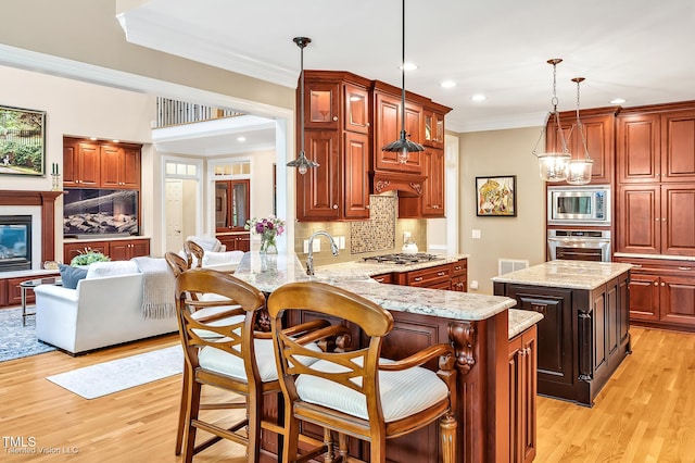 kitchen featuring appliances with stainless steel finishes, recessed lighting, decorative backsplash, crown molding, and light wood-style floors