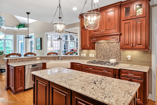 kitchen featuring appliances with stainless steel finishes, a sink, a chandelier, healthy amount of natural light, and lofted ceiling