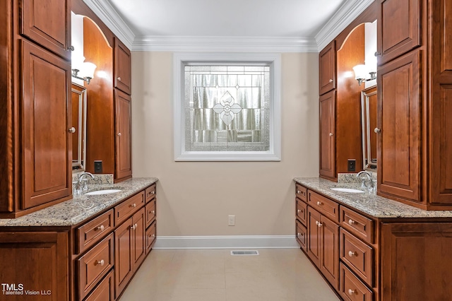 bathroom featuring two vanities, crown molding, tile patterned flooring, and baseboards