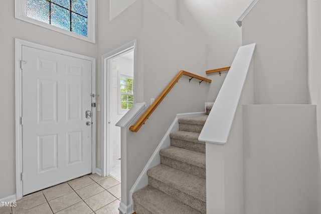 tiled foyer with stairway and baseboards